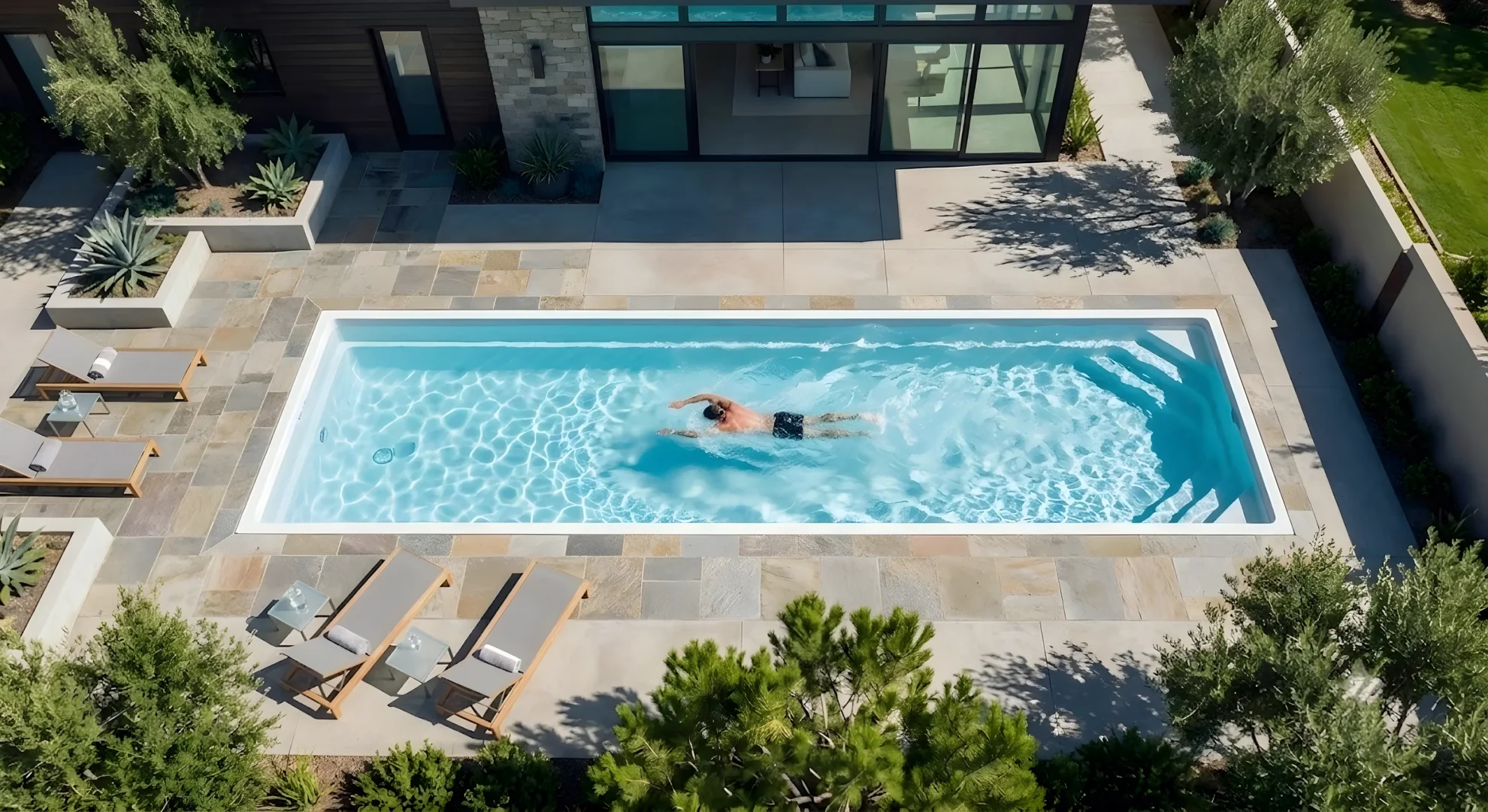 Fiberglass pool with a wide sun ledge ready for loungers